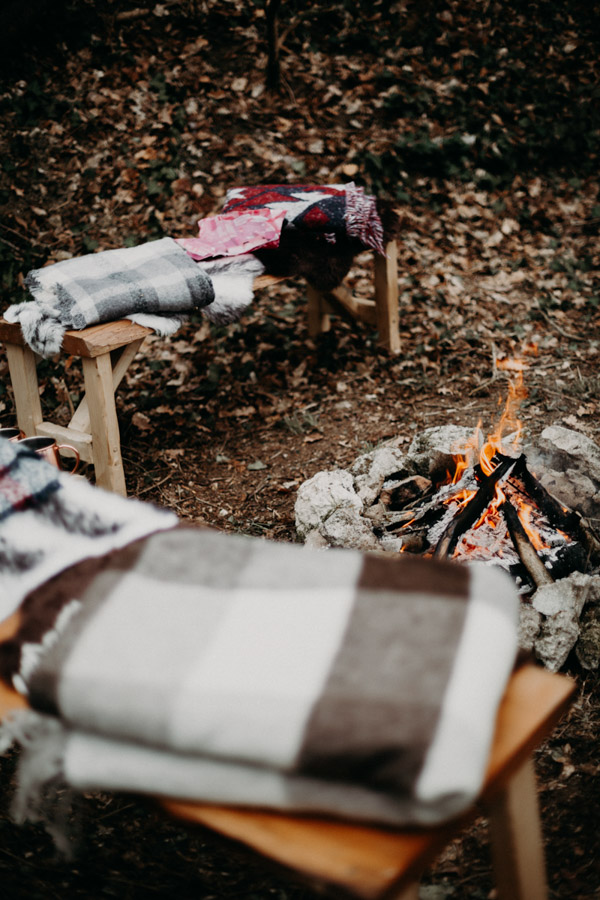 bancs avec couvertures autour d'un feu de camp