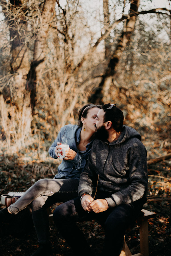 couple qui s'embrasse devant un feu de camp
